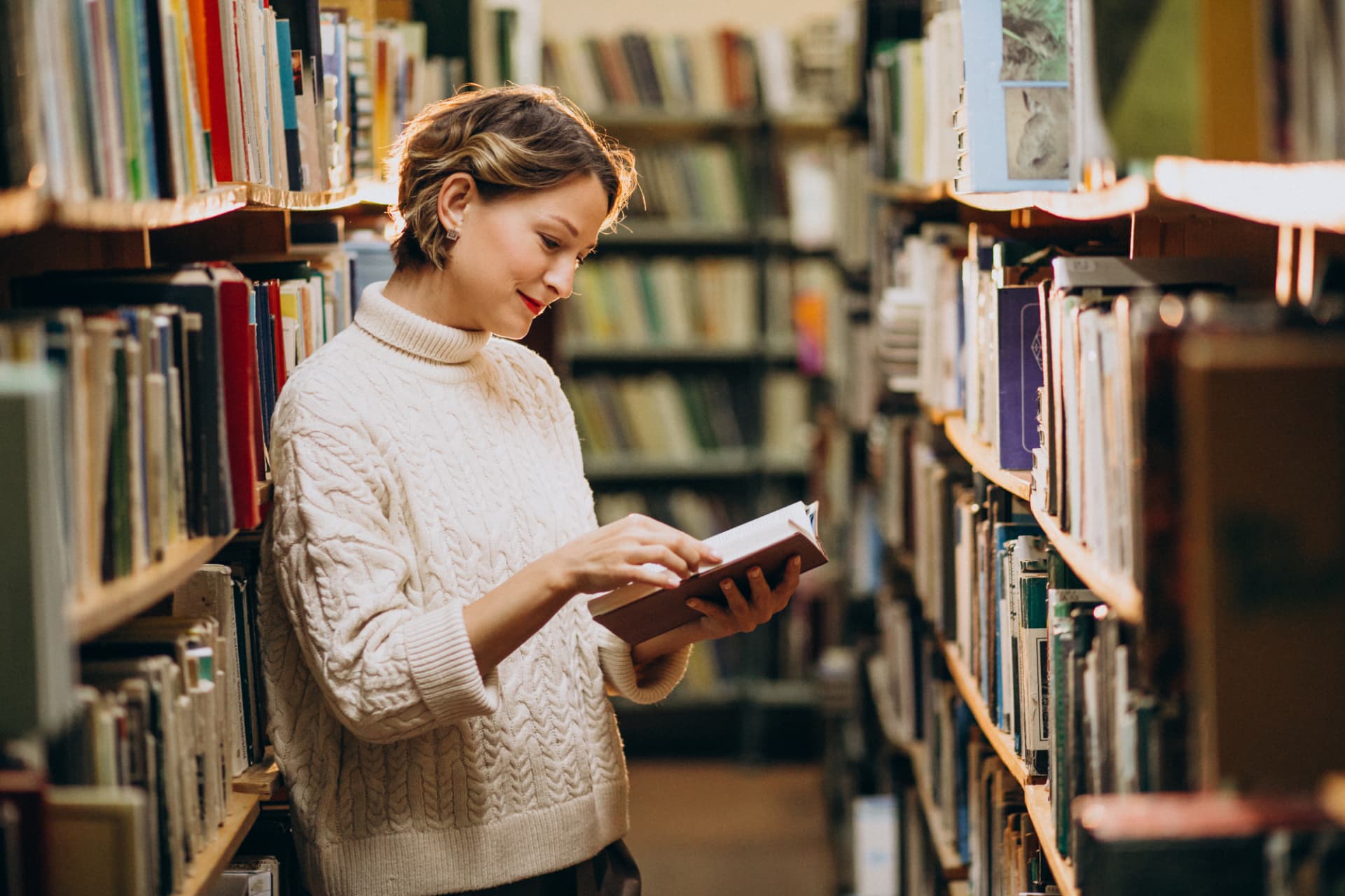A young author studying her manuscript at a library desk
